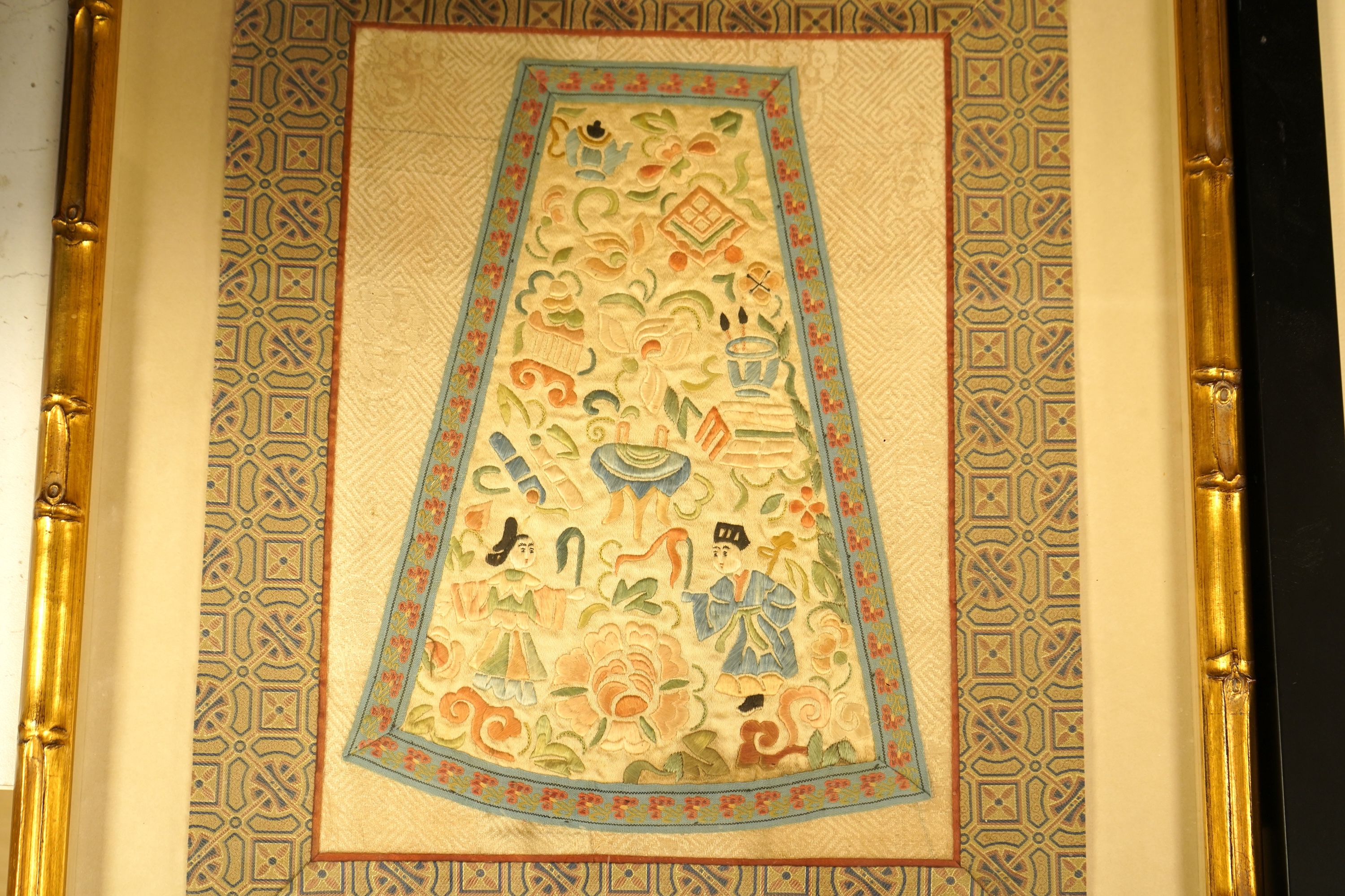Two Chinese silk panels with polychrome embroidery, one housed in a faux bamboo frame, largest 47cm high